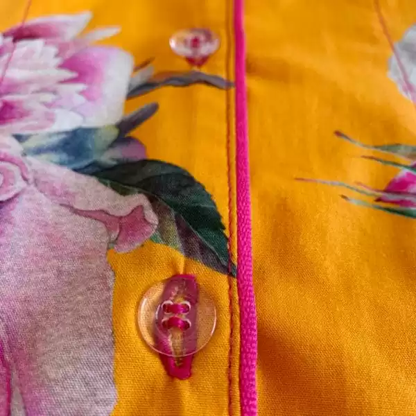 Detalhe de acabamento e botões do pijama Naps na estampa Tropicália