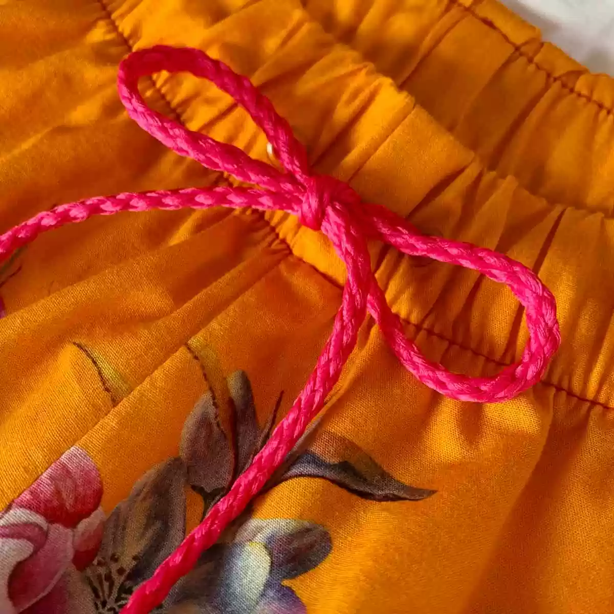 Detalhe do elástico e do cordão do shorts e da calça do pijama Naps na estampa Tropicália