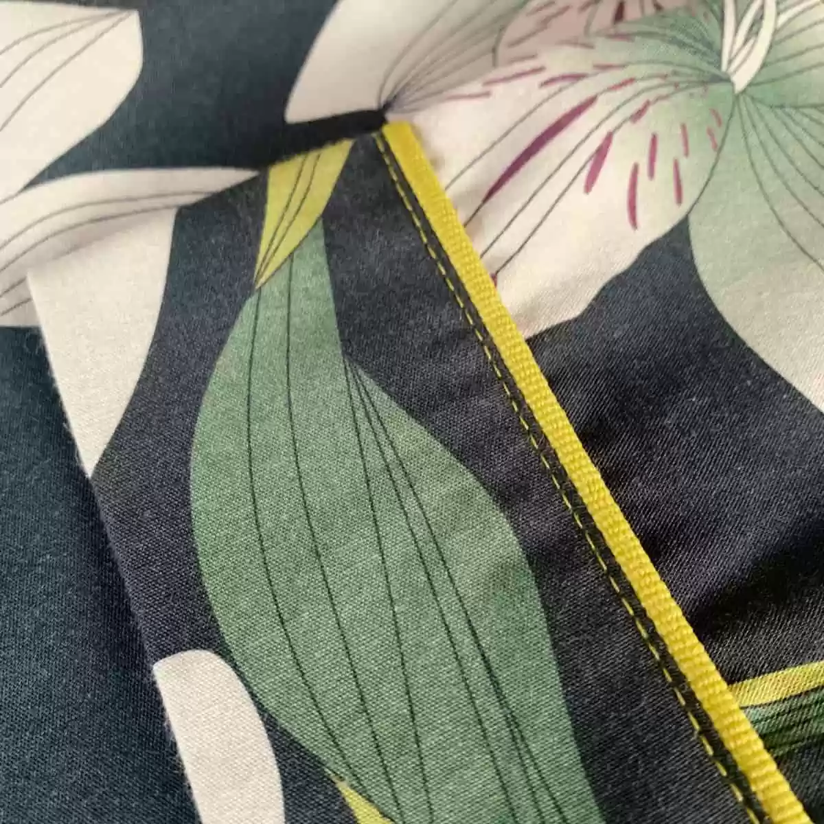 Detalhe da manga da camisa do pijama Naps, mostrando acabamento com vivo e pesponto na estampa Encanto Noturno