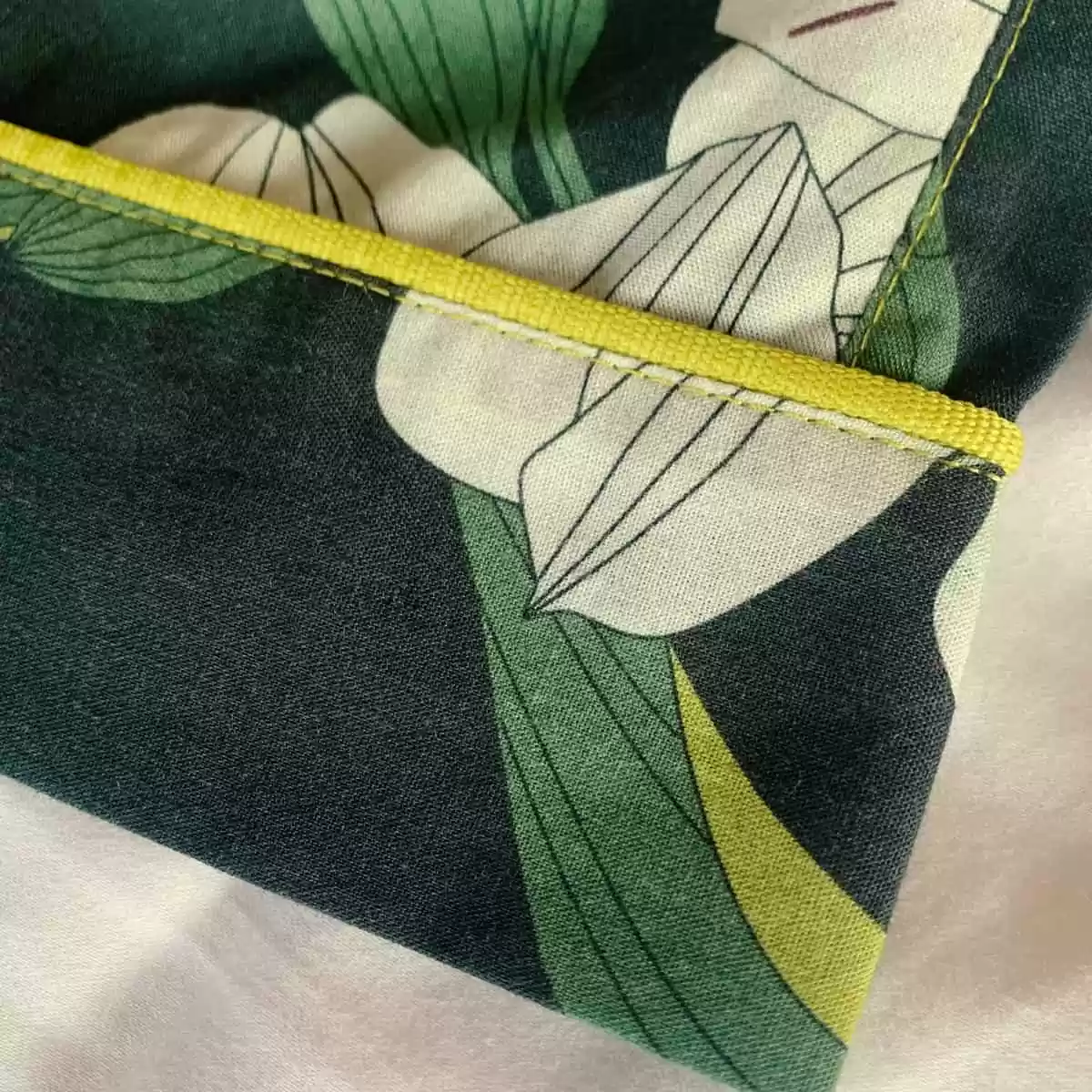 Detalhe do acabamento do shorts e da calça do pijama Naps, com vivo e pesponto na estampa Encanto Noturno