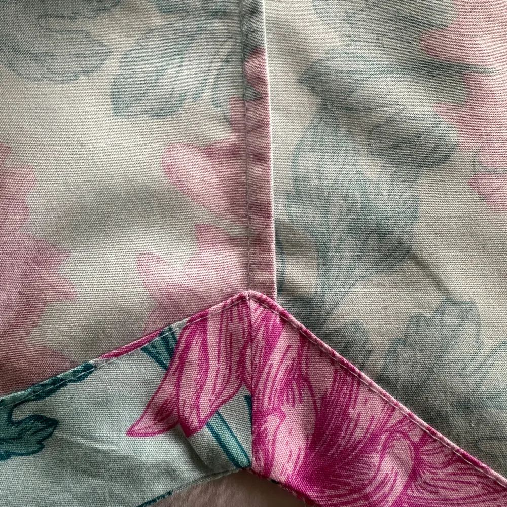Detalhe interno da camisa do pijama Naps, mostrando barra com revel e costura lateral francesa na estampa Bouquet Celeste