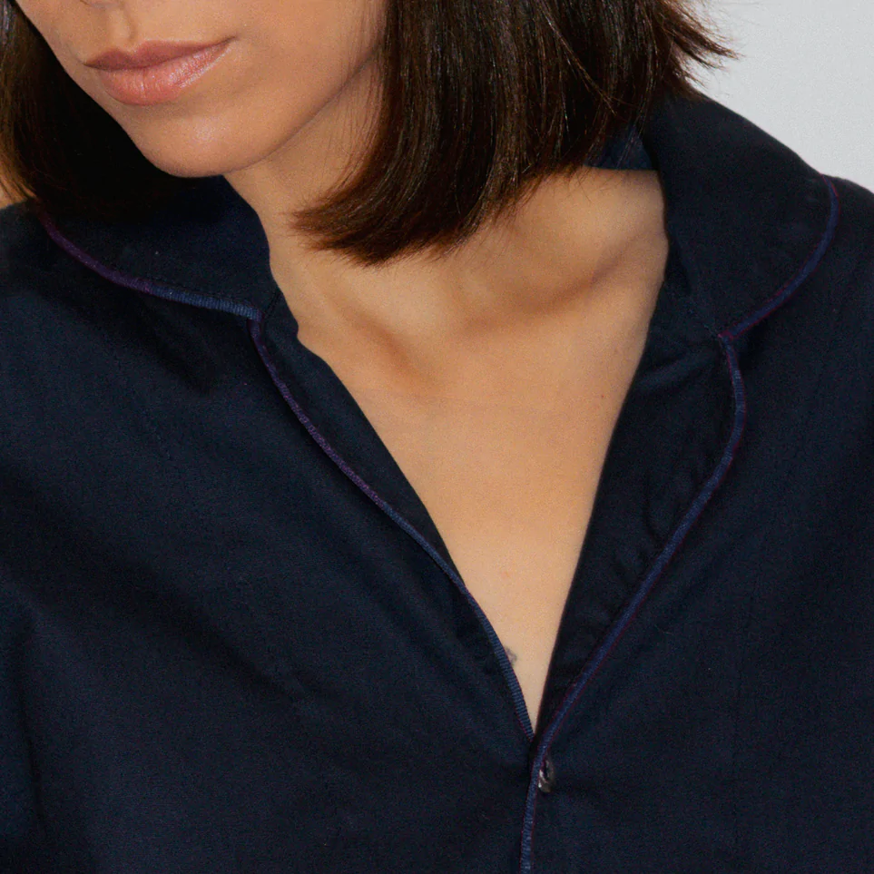 Detalhe do pijama azul-marinho da Naps com acabamento no mesmo tom, mostrando a gola e o vivo azul-marinho em tecido 100% algodão. TÍTULO (SEO TITLE) LEGENDA (CAPTION) DESCRIÇÃO (SEO DESCRIPTION)